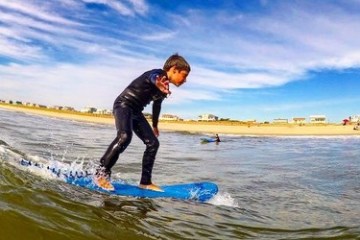 a man riding a wave on a surf board on a body of water