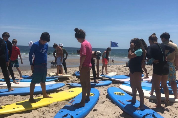 a group of people standing on top of a sandy beach