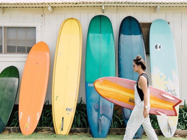 a group of people on a beach holding a surf board