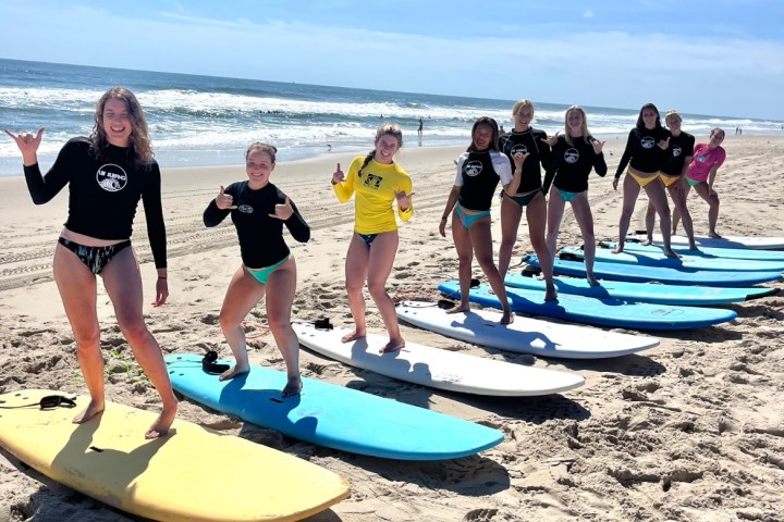 a group of people standing on top of a sandy beach