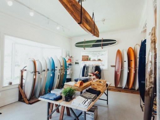Surf shop with surfboards, clothing, and accessories on display.